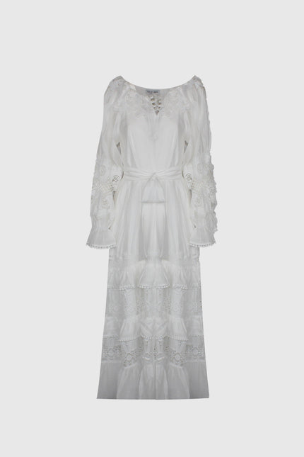 White long boho dress with lace details, tie waist, and flared sleeves on plain background