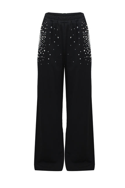 Pantaloni sportivi a palazzo neri in cotone con tasche di strass su sfondo bianco.