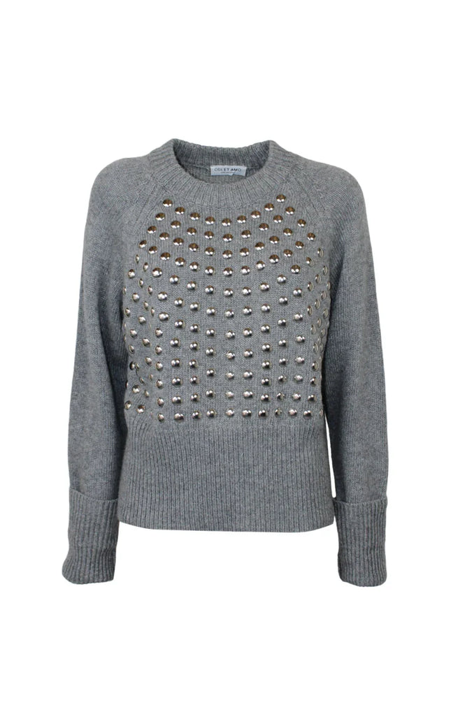 Grey knit women's sweater with metallic stud embellishments on the front, long sleeves.