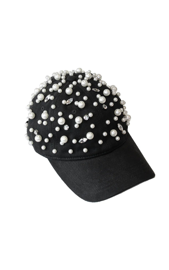 Black baseball cap decorated with pearls and rhinestones on white background
