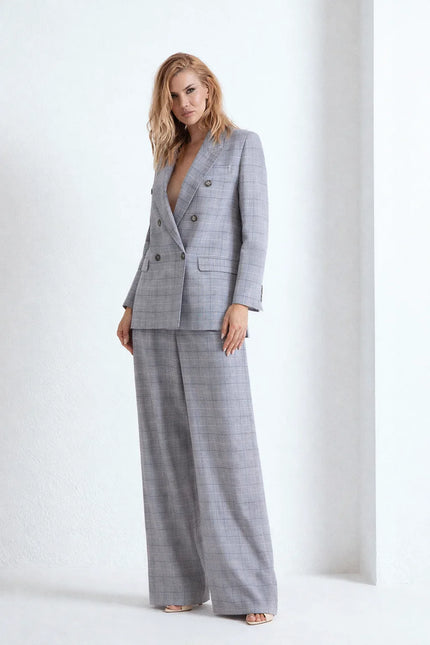 Completo sartoriale grigio a quadri con blazer e pantaloni.