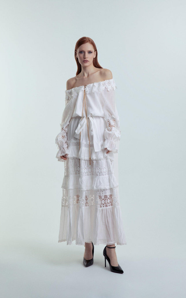 Woman wearing off-shoulder white lace maxi dress with ruffle details, fashion studio shot