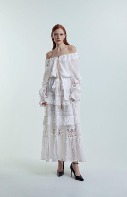 Woman wearing off-shoulder white lace maxi dress with ruffle details, fashion studio shot