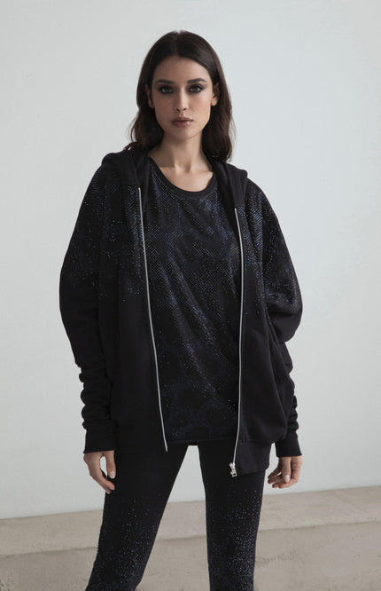 Woman wearing black sparkling hoodie, matching t-shirt and leggings, modern minimalist style