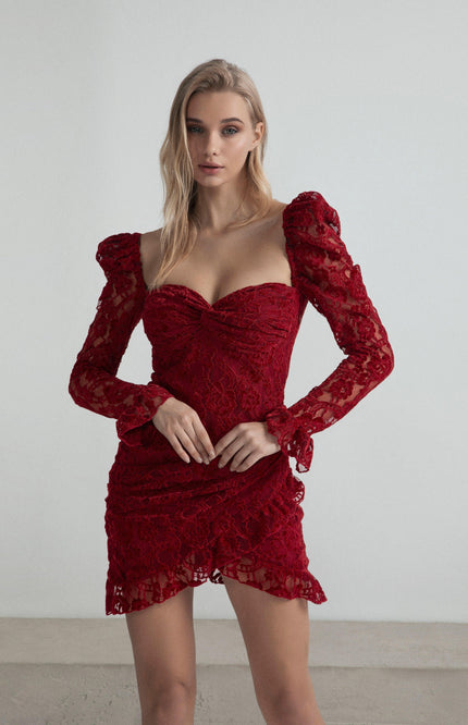 Woman wearing a fitted red lace mini dress with puffed long sleeves