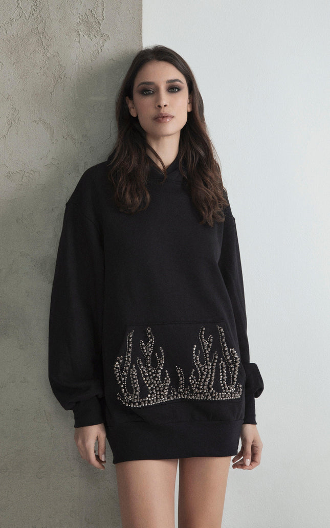 Woman wearing black oversized sweatshirt dress with rhinestone flame details