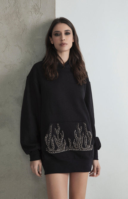 Woman wearing black oversized sweatshirt dress with rhinestone flame details