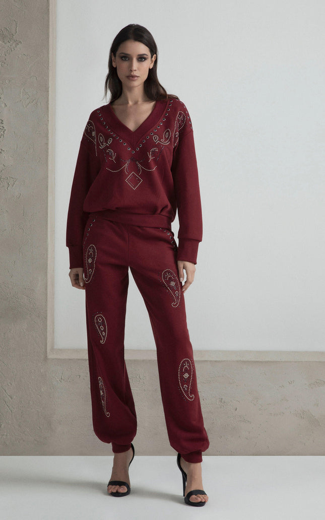 Woman in burgundy embellished lounge set with paisley details and black heels