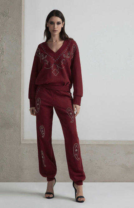Woman in burgundy embellished lounge set with paisley details and black heels