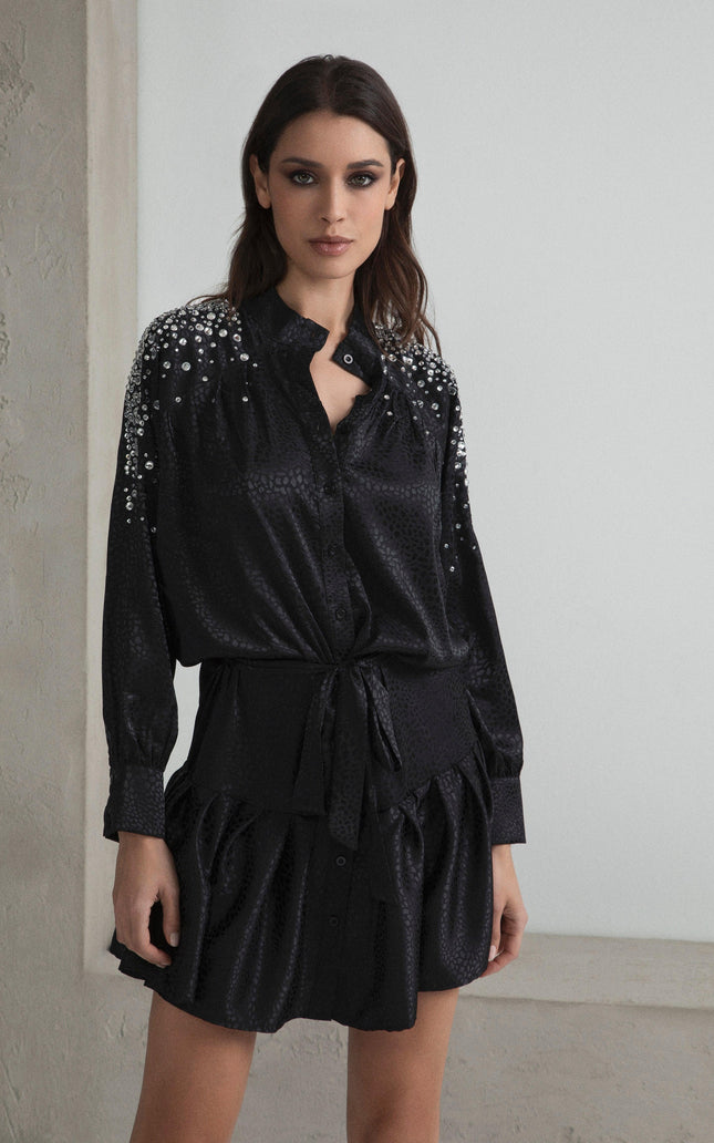 Woman wearing black satin mini dress with sequin details and button front, fashion look