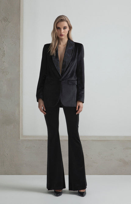 Woman in elegant black tailored suit with flared pants and deep V-neck blazer