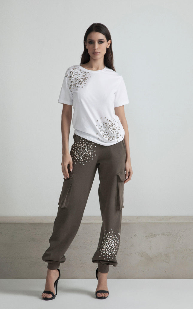Woman wearing a white embellished t-shirt and khaki cargo pants with crystal details