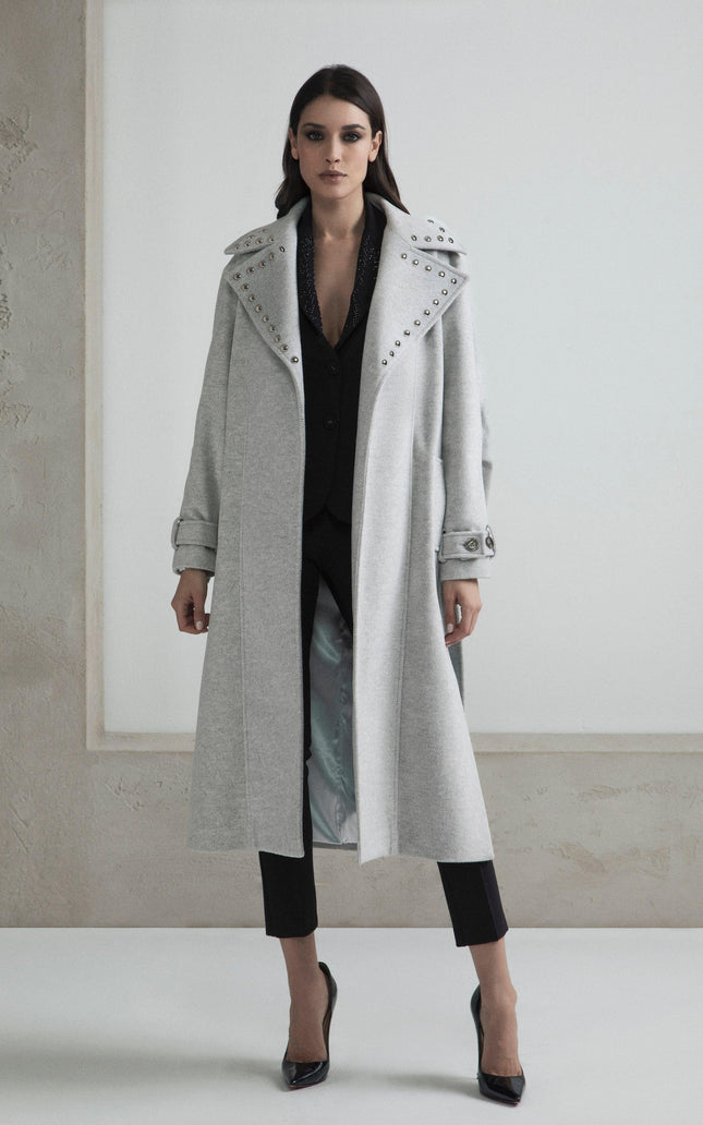 Woman in a long grey coat with studded collar, black suit and heels, fashion outfit