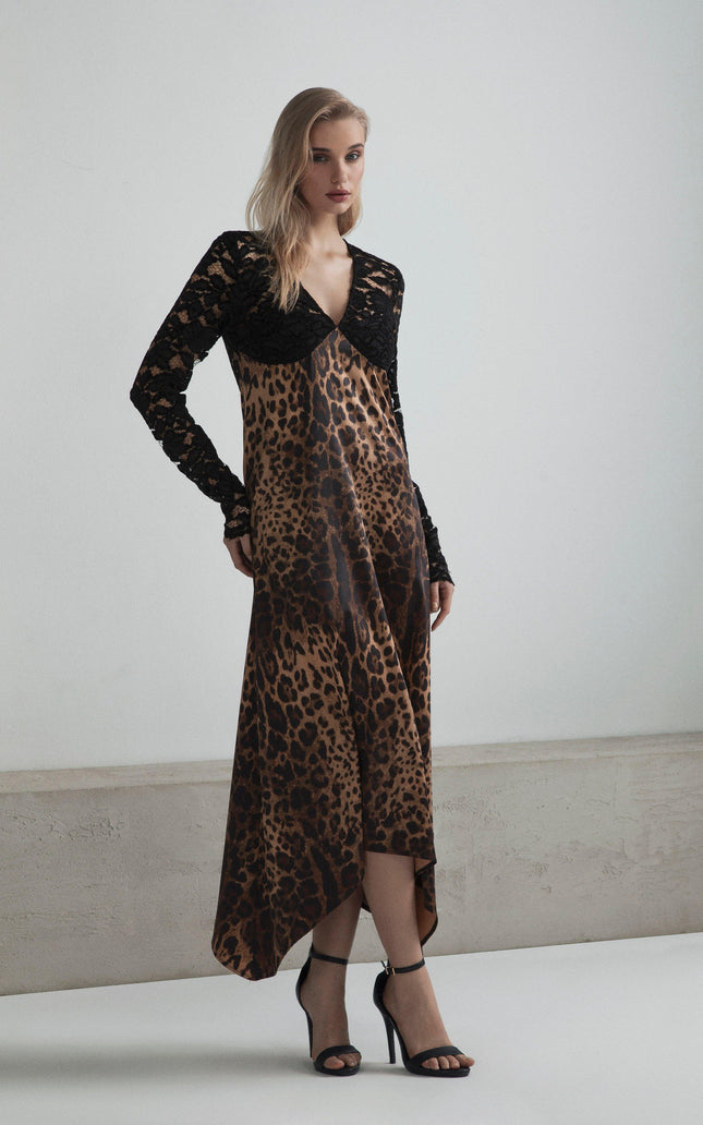 Woman wearing a leopard print dress with black lace sleeves and high heels, standing indoors