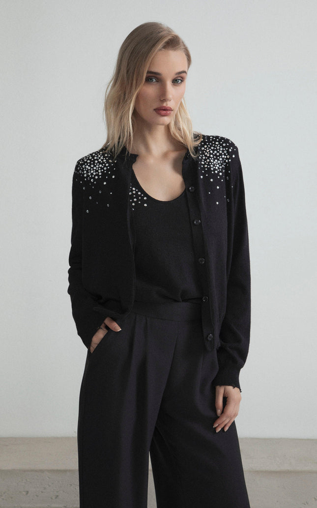 Woman wearing black cardigan with pearl embellishments and black wide-leg pants