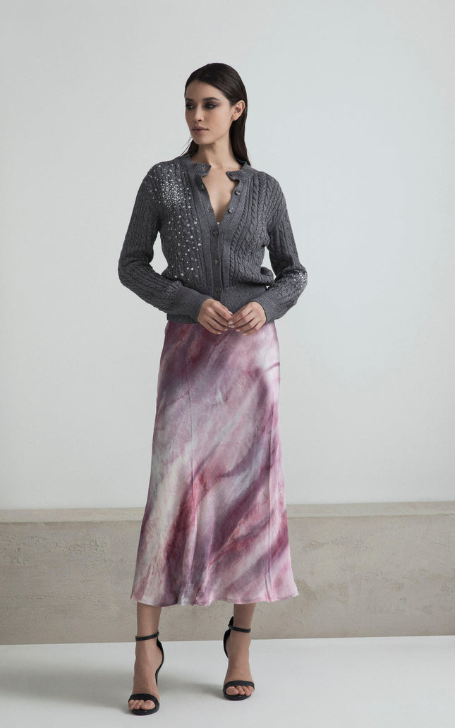 Woman in grey embellished cardigan and pink marble print midi skirt, fashion outfit