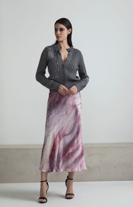 Woman in grey embellished cardigan and pink marble print midi skirt, fashion outfit