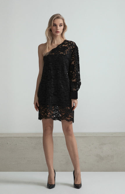 Woman wearing a black lace one-shoulder dress with long sleeve and scalloped hem