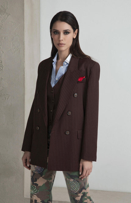 Woman in oversized pinstripe blazer, striped shirt, and embellished camouflage pants