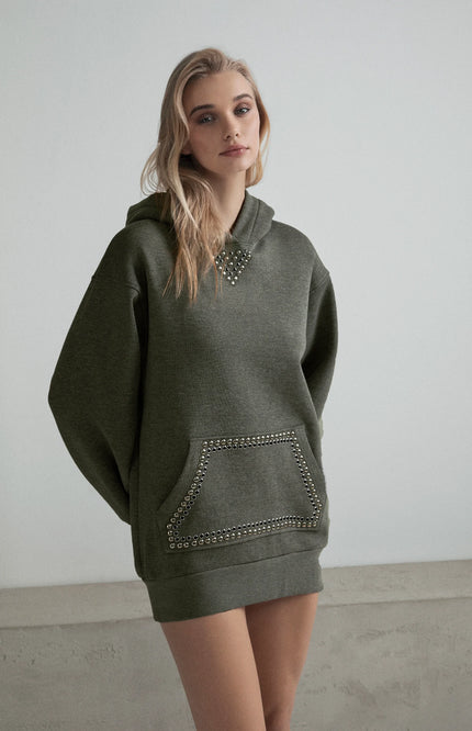Woman wearing oversized military green hoodie dress with studded details