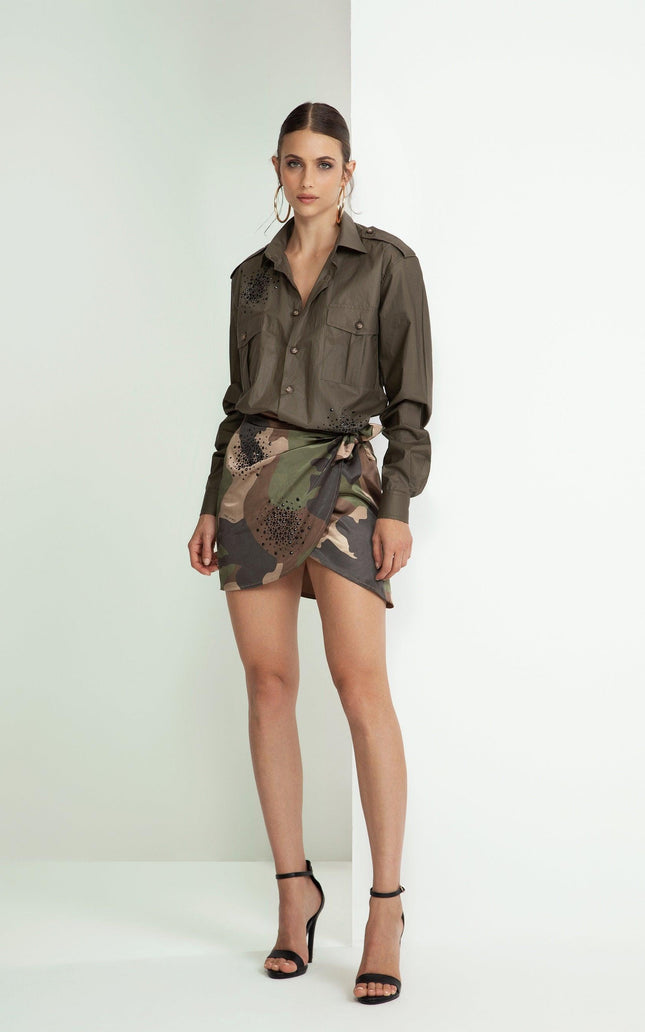 Woman in khaki shirt with black details and camo wrap mini skirt, high heels