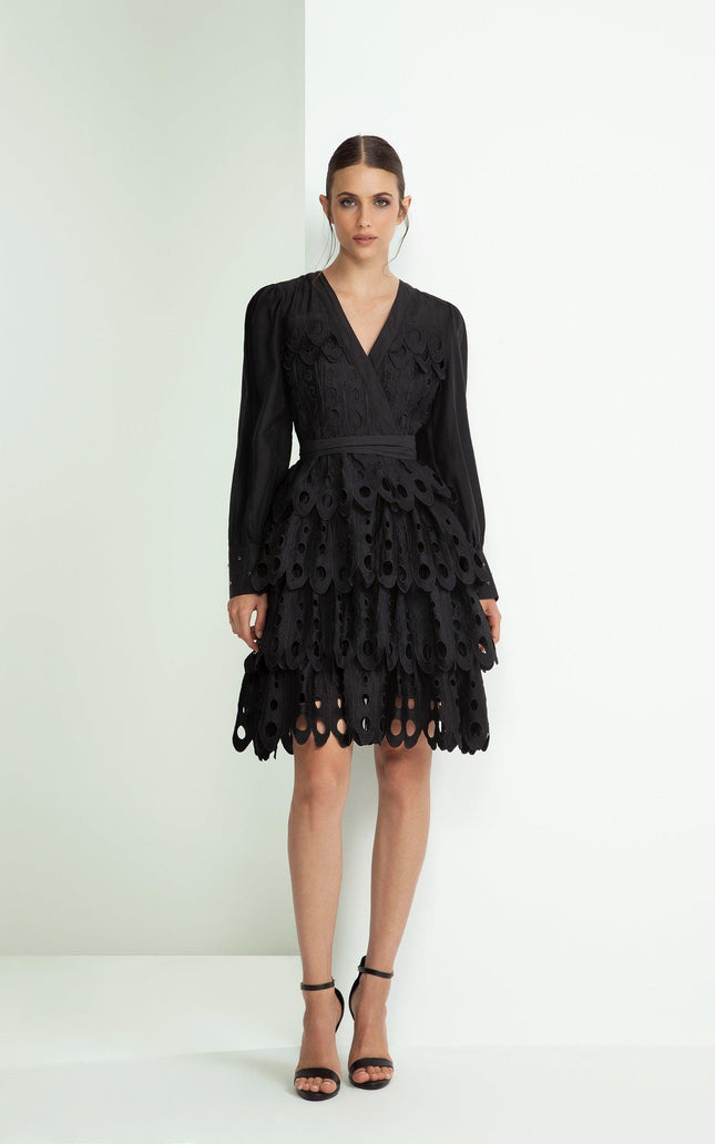 Woman in black long-sleeve scalloped mini dress with cutout layered skirt, fashion look