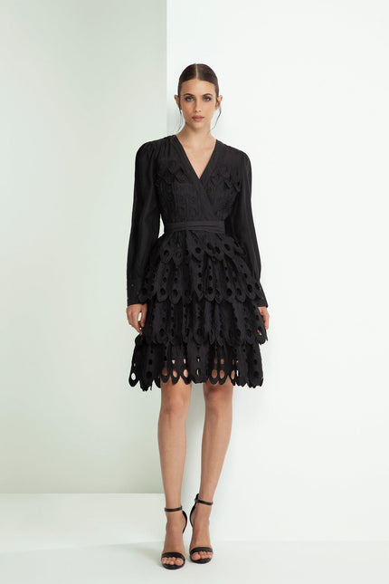 Woman in black long-sleeve scalloped mini dress with cutout layered skirt, fashion look