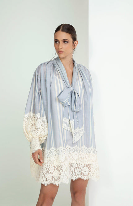 Woman wearing a light blue striped mini dress with lace trim and bow detail, fashion look