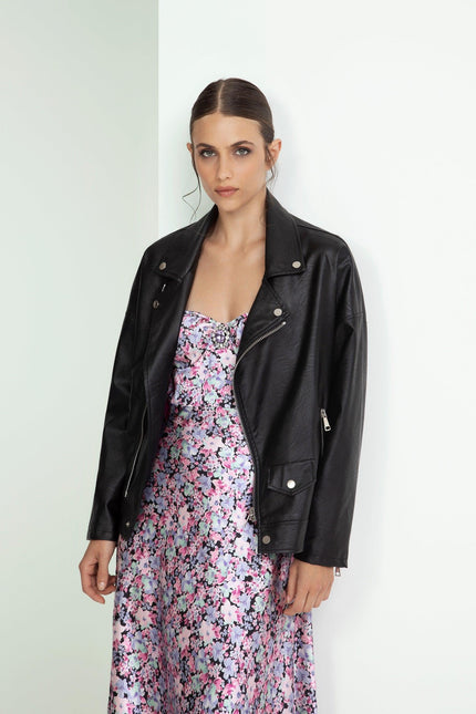 Woman in black leather jacket over a pink floral dress, modern and elegant fashion style