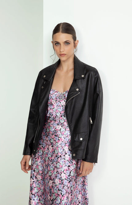 Woman in black leather jacket over a pink floral dress, modern and elegant fashion style
