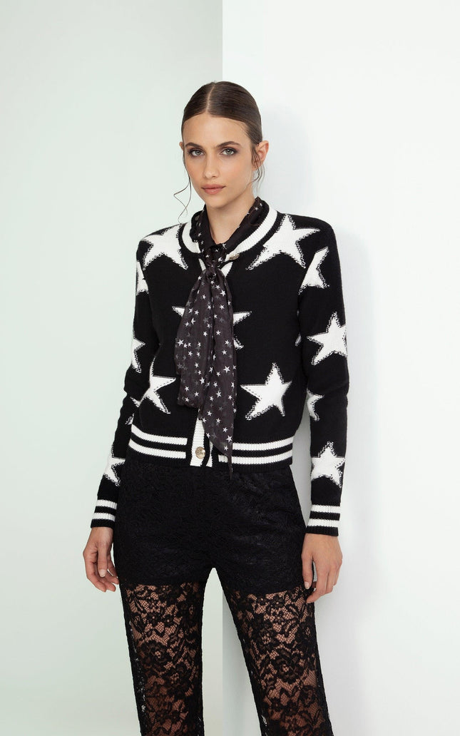 Woman in star print black and white cardigan with polka dot scarf and lace pants