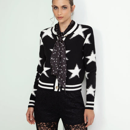 Woman in star print black and white cardigan with polka dot scarf and lace pants