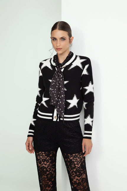 Woman in star print black and white cardigan with polka dot scarf and lace pants