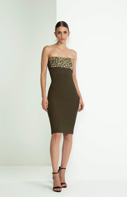 Woman wearing strapless dark olive green fitted dress with gold sequin details