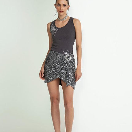 Woman in a sleeveless black top and sequin mini skirt with high heels, fashion photoshoot