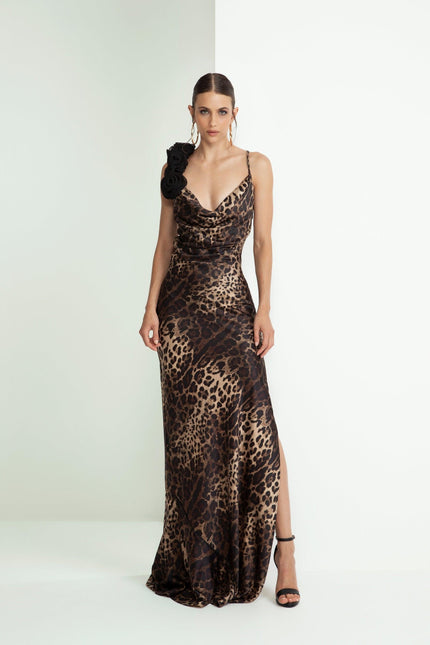Woman in a leopard print evening gown with black floral shoulder detail and side slit