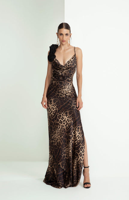 Woman in a leopard print evening gown with black floral shoulder detail and side slit