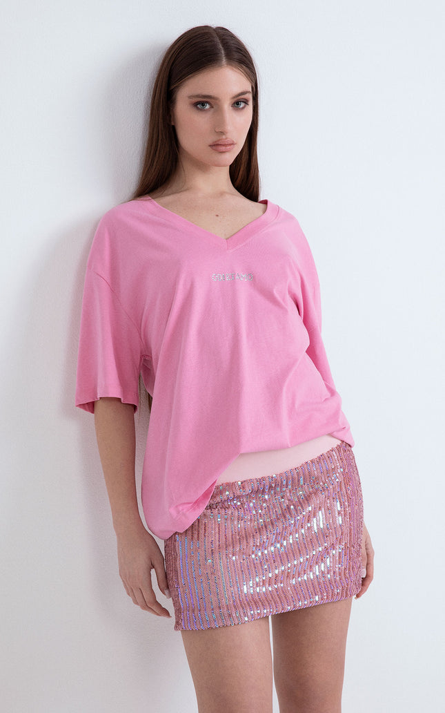 Outfit con t-shirt fucsia oversize a maniche corte e gonna corta di paillettes
