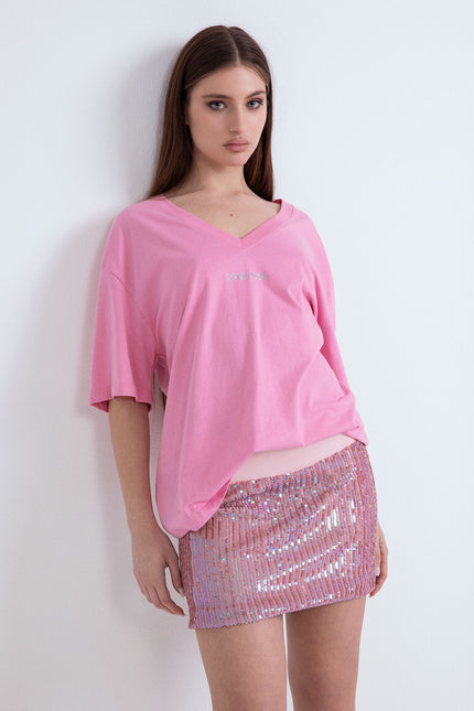 Outfit con t-shirt fucsia oversize a maniche corte e gonna corta di paillettes
