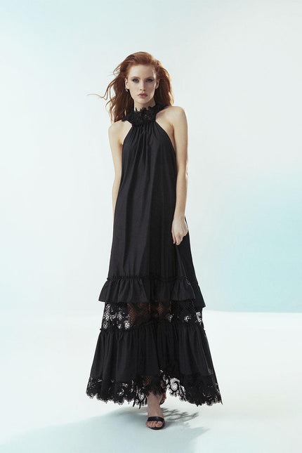 Woman in a long black halter dress with lace details, fashion photoshoot