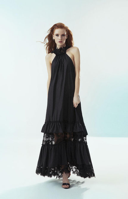 Woman in a long black halter dress with lace details, fashion photoshoot