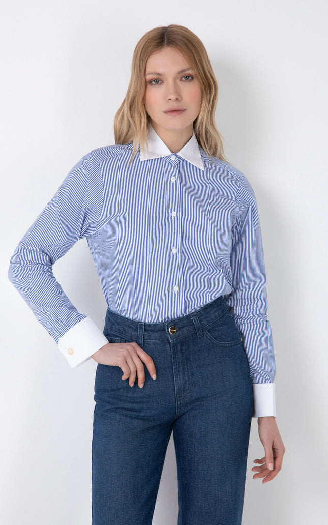 Woman wearing blue striped long-sleeve shirt with white collar and cuffs and blue jeans