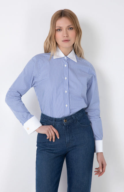 Woman wearing blue striped long-sleeve shirt with white collar and cuffs and blue jeans
