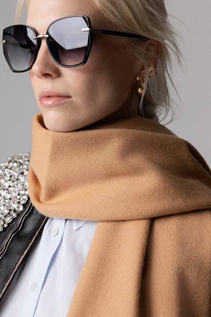 Modella con occhiali da sole che indossa una sciarpa donna in lana di agnello color cammello