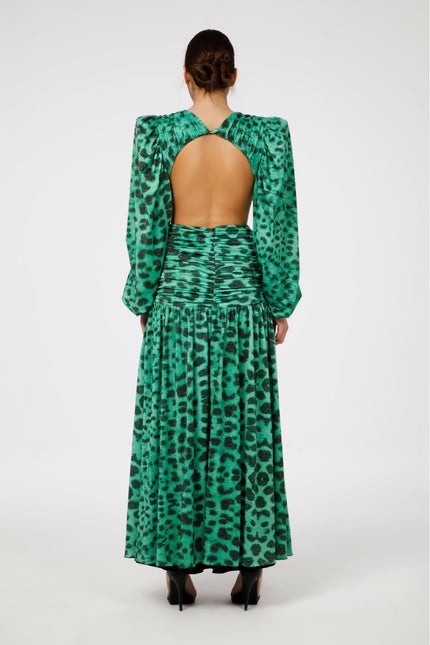 Woman in green leopard print dress with open back and long sleeves, back view